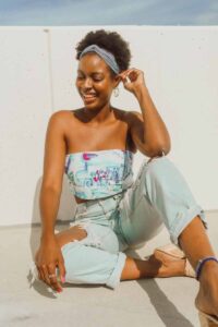 Smiling woman wearing headband sitting on ground